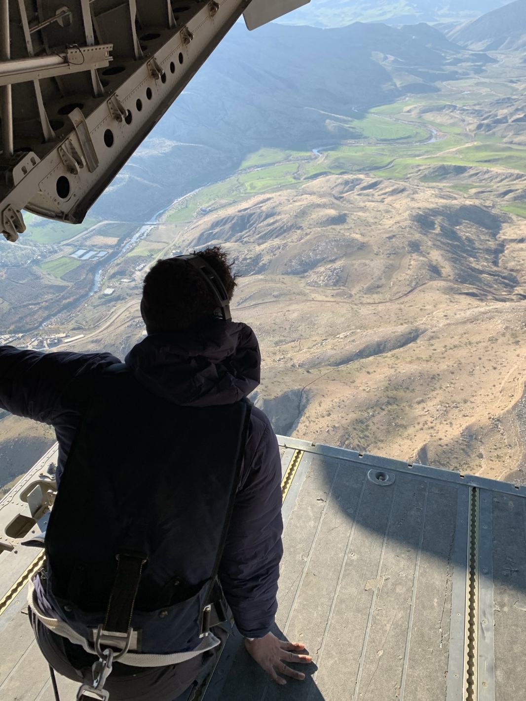 Wide landscape view from an open aircraft doorway.