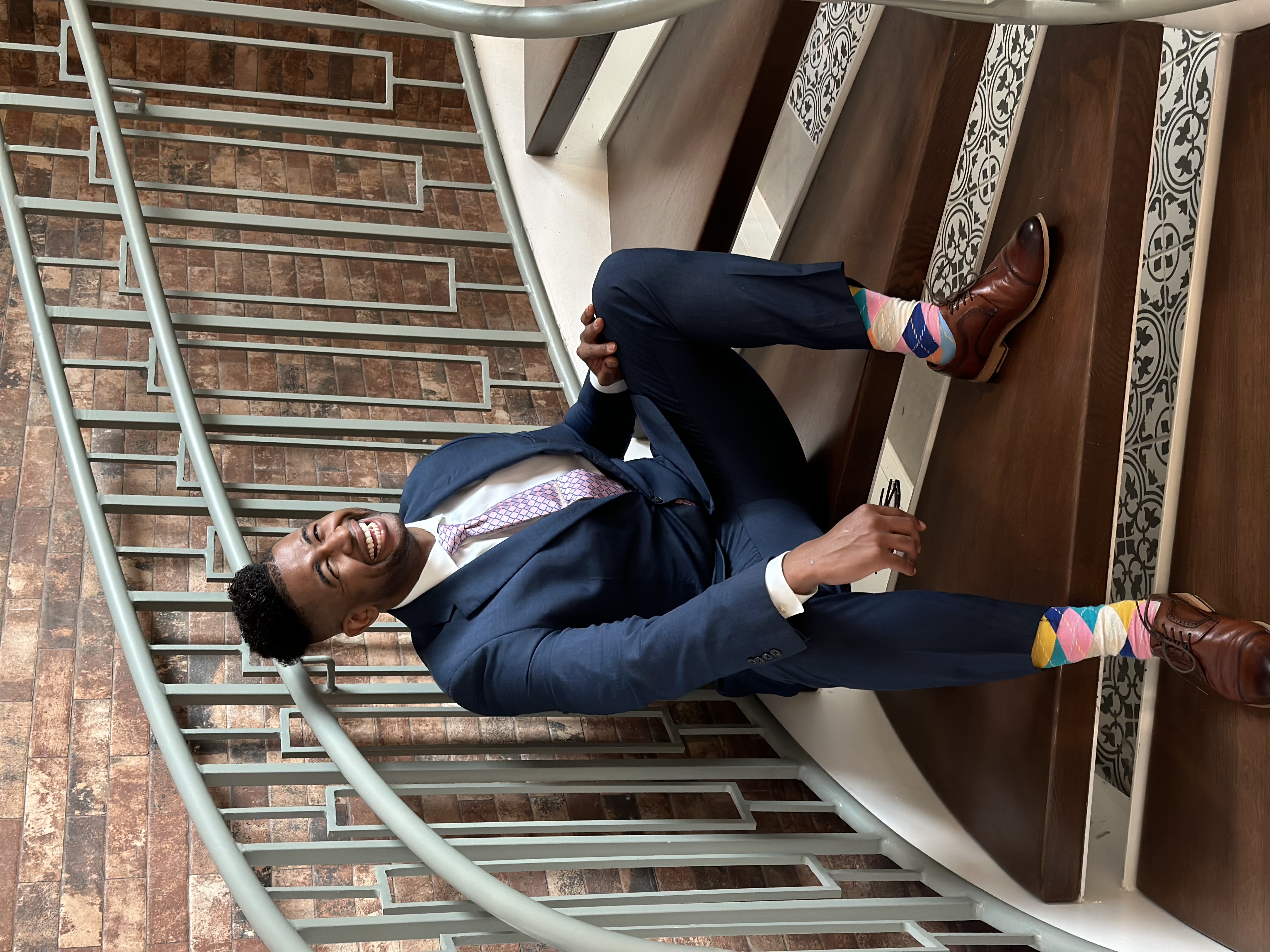 Joseph Robinson seated on stairs, smiling.